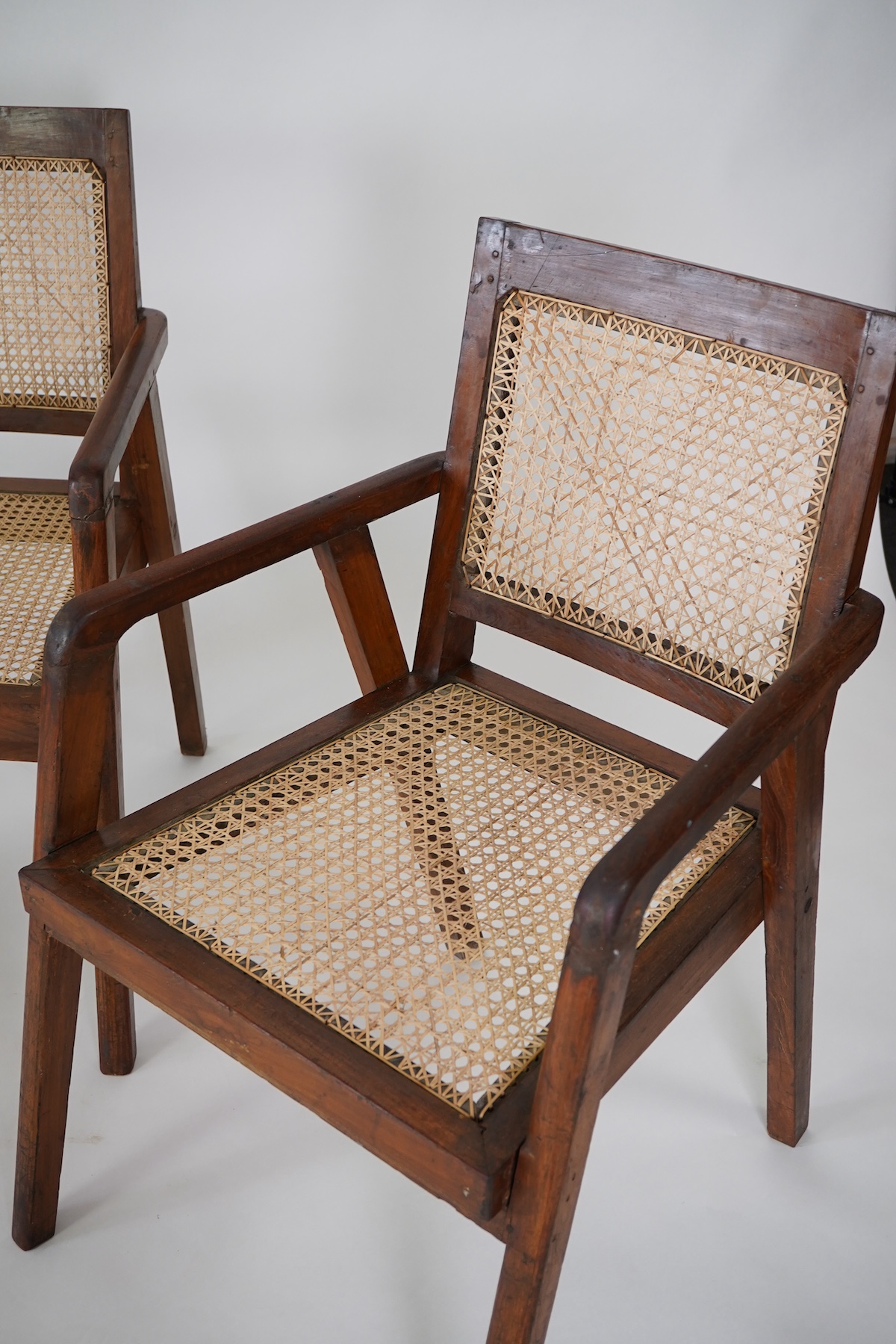 Manner of Pierre Jeanneret (Swiss, 1896-1967): A set of four solid teak and braided canework armchairs